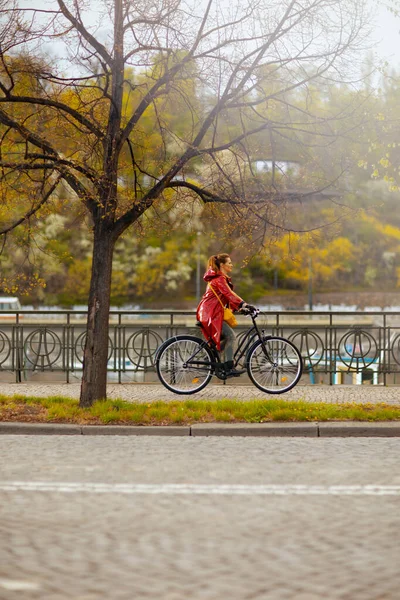 Nowoczesna Kobieta Czerwonym Płaszczu Przeciwdeszczowym Zewnątrz Mieście Jazda Rowerze — Zdjęcie stockowe