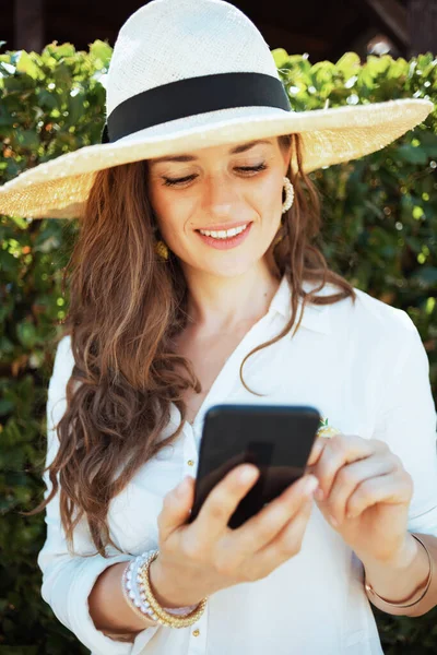 Modern Middle Aged Woman White Shirt Hat Using Smartphone App — Foto Stock