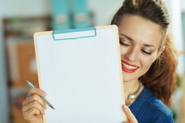 Mutlu modern 40 yıl. Ofisinde panosu olan küçük işletme sahibi kadın..