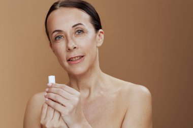 smiling modern woman with hygienic lipstick against beige background.