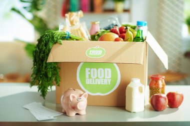 Food delivery. table with food box and piggy bank in the kitchen.