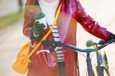 Şehrin dışında bisiklet ve bir fincan sıcak kakaolu bir kadına yakın çekim..