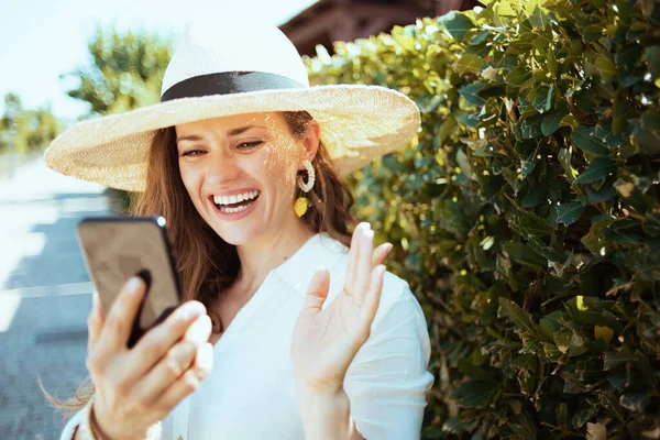 Счастливая Молодая Женщина Белой Рубашке Шляпе Отвечает Входящий Видеозвонок Смартфон — стоковое фото