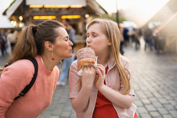 Smiling Modern Mother Daughter Fair City Eating Trdelnik - Stock-foto