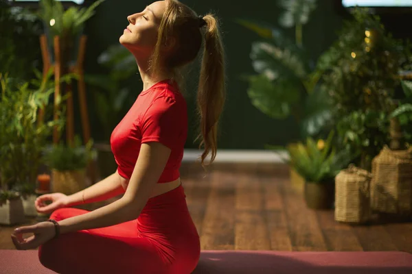 Modern Yeşil Evde Yoga Yapan Kırmızı Spor Elbiseli Rahat Genç — Stok fotoğraf