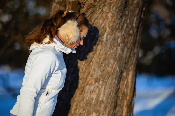 Healthy Woman White Jacket Ear Warmer Catching Breath Exercise Tree — Stockfoto