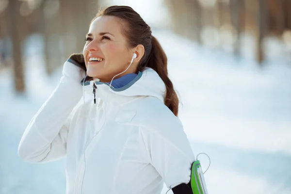 Smiling Fit Woman White Jacket Headphones Outdoors City Park Winter — Stock fotografie