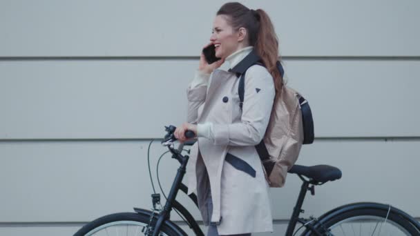 Счастливая Современная Летняя Женщина Бежевом Плаще Велосипедом Рюкзаком Зеленой Стены — стоковое видео