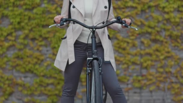 Elegant Woman Beige Trench Coat Bicycle Backpack Green Wall Outdoors — Video Stock