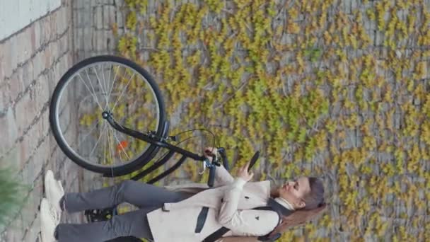Портрет Елегантної Жінки Бежевому Траншеї Велосипедом Рюкзаком Відправляє Текстове Повідомлення — стокове відео