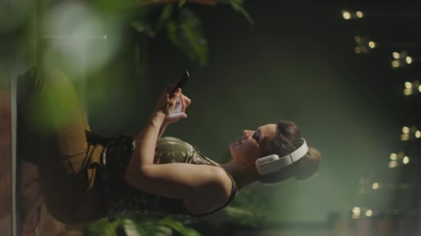 在现代绿色之家 40岁的女人带着耳机做瑜伽 很休闲时尚 — 图库视频影像