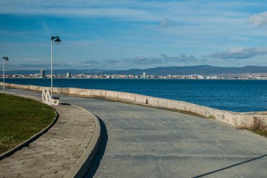 Panorama with deserted sea promenade alley in clear sunny day
