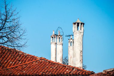 Eski çatılar ve bacalar mavi gökyüzü arkaplanına yakın