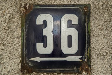 Yıpranmış, köhne, metal plakalı, 36 numaralı sokak adresi.