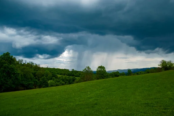 Yağmur sırasında dramatik fırtınalı bulutlarla kaplı dağ manzarası