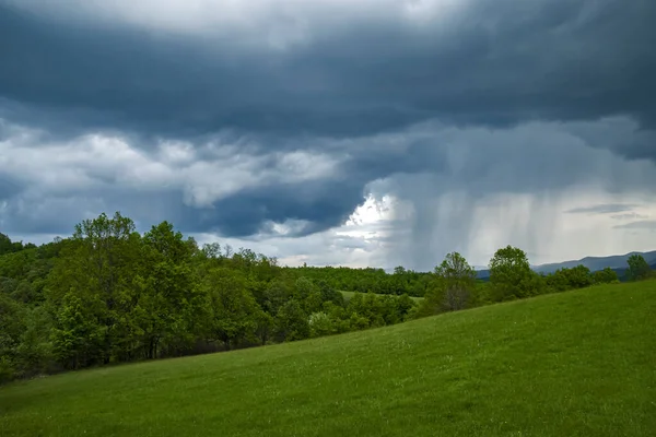 Yağmur sırasında dramatik fırtınalı bulutlarla kaplı dağ manzarası