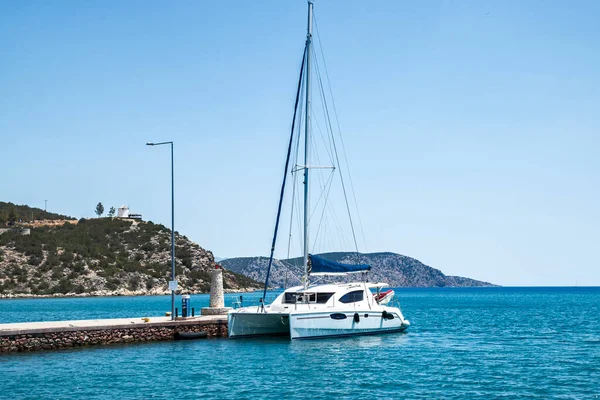 Sailing catamaran moored at sea pier on Mediterranean sea