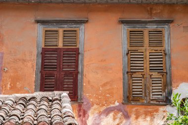 Eski Akdeniz evinin ön cephesinde ahşap panjurlu pencereler