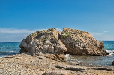 Güneşli yaz günlerinde sakin deniz arka planında kumlu kumsalın yanında güzel uçurumlar