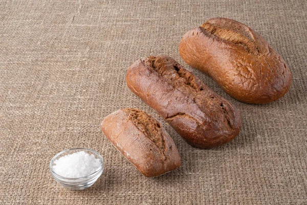 Bread, traditional sourdough bread, on a background of burlap. The concept of traditional ways of baking yeast bread. Healthy eating.