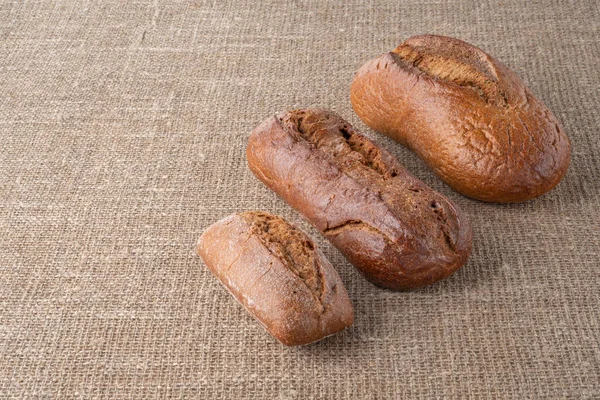 Bread, traditional sourdough bread, on a background of burlap. The concept of traditional ways of baking yeast bread. Healthy eating.