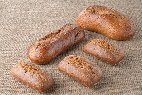 Bread, traditional sourdough bread, on a background of burlap. The concept of traditional ways of baking yeast bread. Healthy eating.