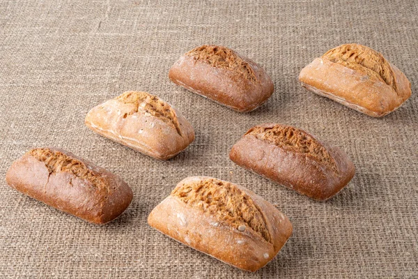 Bread, traditional sourdough bread, on a background of burlap. The concept of traditional ways of baking yeast bread. Healthy eating.