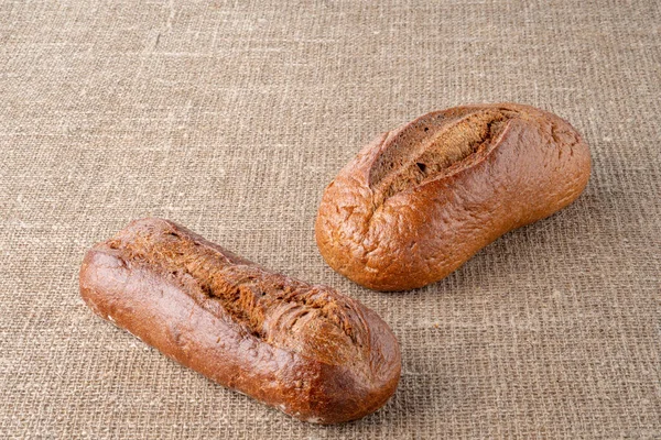 Bread, traditional sourdough bread, on a background of burlap. The concept of traditional ways of baking yeast bread. Healthy eating.