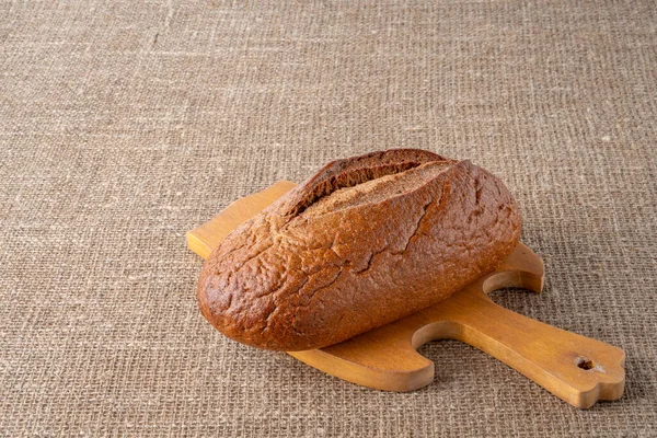 Bread, traditional sourdough bread, on a background of burlap. The concept of traditional ways of baking yeast bread. Healthy eating.