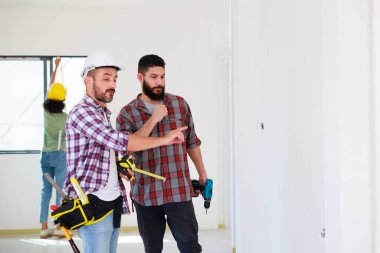 Güvenlik üniformalı iki inşaat mühendisi ekip inşaat alanında çalışıyor. Bakım servisi Tamir ve Tamirci konsepti