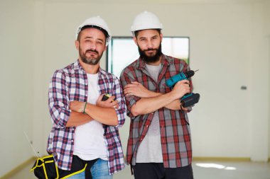 Güvenlik üniformalı iki inşaat mühendisi ekip inşaat alanında çalışıyor. Bakım servisi Tamir ve Tamirci konsepti