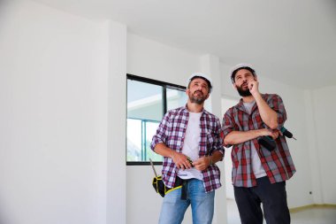 Güvenlik üniformalı iki inşaat mühendisi ekip inşaat alanında çalışıyor. Bakım servisi Tamir ve Tamirci konsepti