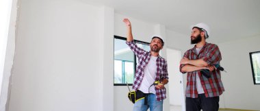 Güvenlik üniformalı iki inşaat mühendisi ekip inşaat alanında çalışıyor. Bakım servisi Tamir ve Tamirci konsepti