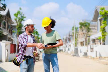 Paten ve renk paletli bir ressam. Genç Afrikalı Amerikalı kadın ve İspanyol inşaat işçisi gülümseyen inşaatçılar