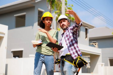 Paten ve renk paletli bir ressam. Genç Afrikalı Amerikalı kadın ve İspanyol inşaat işçisi gülümseyen inşaatçılar