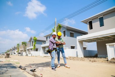Paten ve renk paletli bir ressam. Genç Afrikalı Amerikalı kadın ve İspanyol inşaat işçisi gülümseyen inşaatçılar