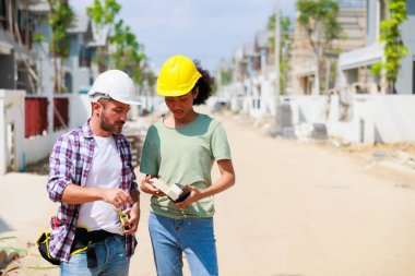 Paten ve renk paletli bir ressam. Genç Afrikalı Amerikalı kadın ve İspanyol inşaat işçisi gülümseyen inşaatçılar
