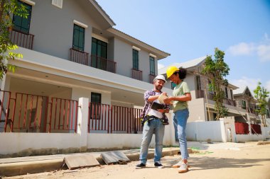 Paten ve renk paletli bir ressam. Genç Afrikalı Amerikalı kadın ve İspanyol inşaat işçisi gülümseyen inşaatçılar