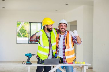 Tokalaşın. Elektrik ve inşaat mühendisi güvenlik üniformalı ekip inşaat alanında çalışıyor ve planlama yapıyor..