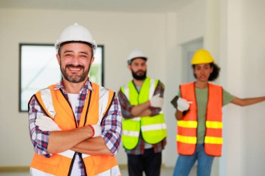 Portre mutlu İspanyol İnşaat İşçisi. Güvenlik kaskı takıyor. İnşaat alanında çalışıyor.. 