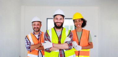 Profesyonel Makine Mühendisi Ekibi, inşaat sahasının altındaki imalat fabrikasında güvenlik kaskı takıyor..