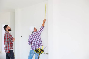 Güvenlik üniformalı iki inşaat mühendisi ekip inşaat alanında çalışıyor. Bakım servisi Tamir ve Tamirci konsepti