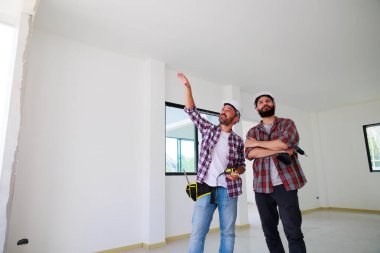 Güvenlik üniformalı iki inşaat mühendisi ekip inşaat alanında çalışıyor. Bakım servisi Tamir ve Tamirci konsepti