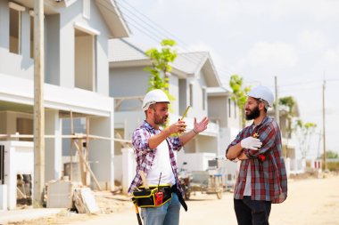 Güvenlik üniformalı iki inşaat mühendisi ekip inşaat alanında çalışıyor. Bakım servisi Tamir ve Tamirci konsepti