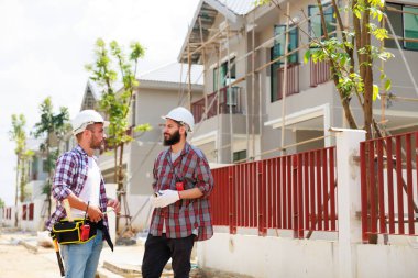 Güvenlik üniformalı iki inşaat mühendisi ekip inşaat alanında çalışıyor. Bakım servisi Tamir ve Tamirci konsepti