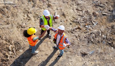 Üst görüntüyü birleştirelim. Başarılı bir takım çalışması birliği. Ev projesinin inşaat alanındaki makine mühendisi ve inşaat ekibi. Eller birleşsin.