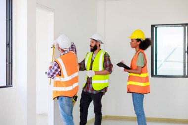 Kapılarda. Profesyonel Makine Mühendisi Ekibi, inşaat sahasının altındaki imalat fabrikasında güvenlik kaskı takıyor..