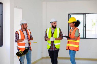 Kapılarda. Profesyonel Makine Mühendisi Ekibi, inşaat sahasının altındaki imalat fabrikasında güvenlik kaskı takıyor..