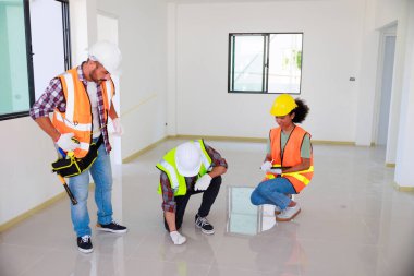 Kapılarda. Profesyonel Makine Mühendisi Ekibi, inşaat sahasının altındaki imalat fabrikasında güvenlik kaskı takıyor..