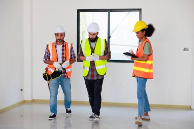 Kapılarda. Profesyonel Makine Mühendisi Ekibi, inşaat sahasının altındaki imalat fabrikasında güvenlik kaskı takıyor..